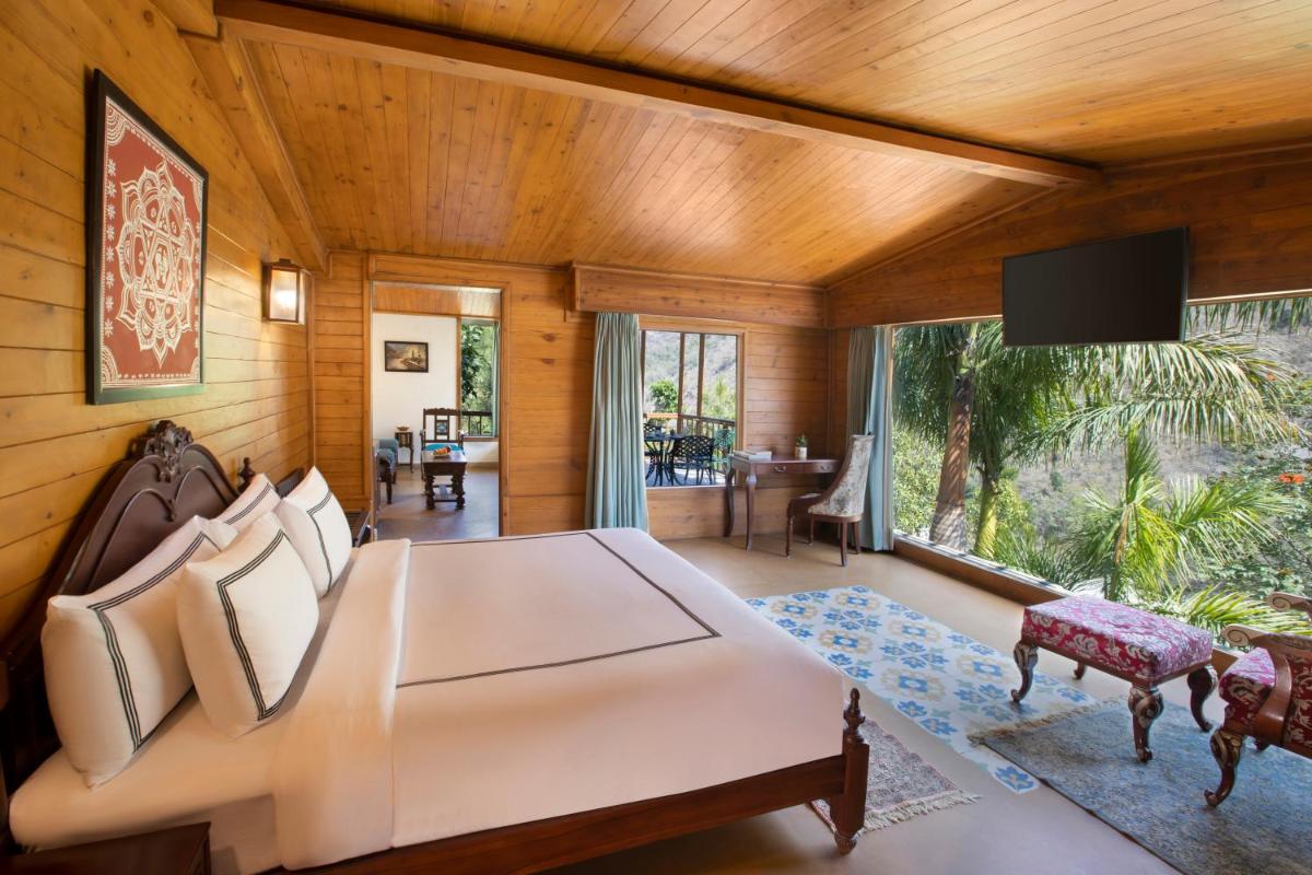 a bedroom with a bed and a large window at Raga on the Ganges, Rishikesh in Rishīkesh