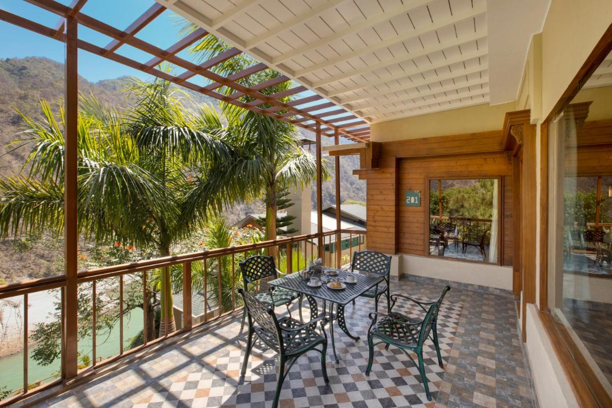 a patio with a table and chairs on a balcony at Raga on the Ganges, Rishikesh in Rishīkesh