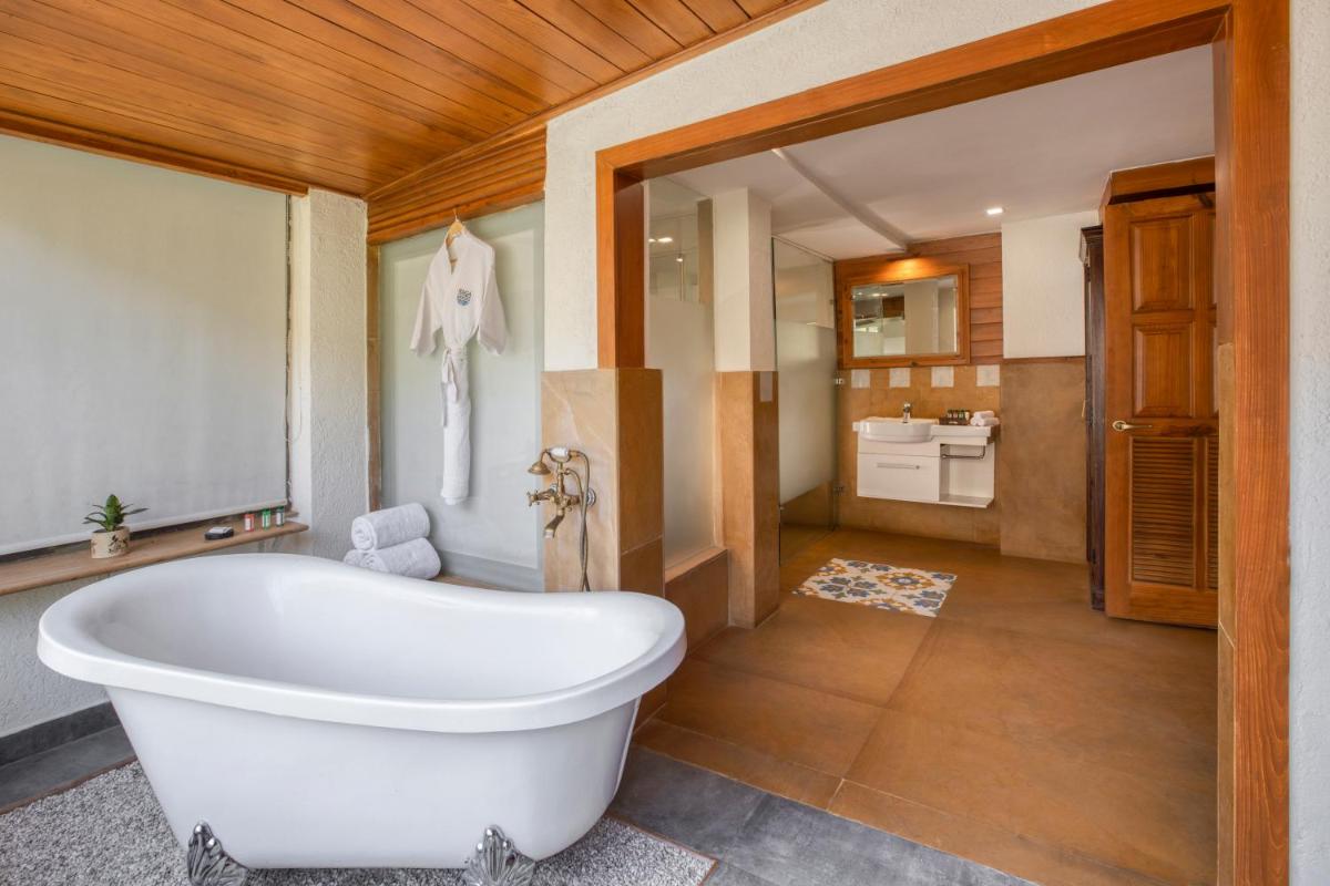a bathroom with a white bath tub in a room at Raga on the Ganges, Rishikesh in Rishīkesh