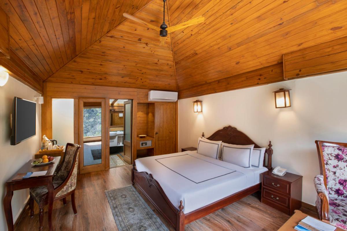 a bedroom with a bed and a wooden ceiling at Raga on the Ganges, Rishikesh in Rishīkesh