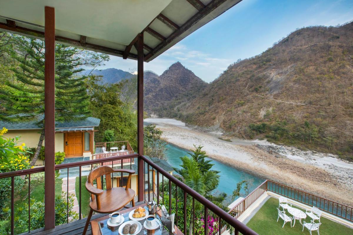 a balcony with a view of a river and mountains at Raga on the Ganges, Rishikesh in Rishīkesh