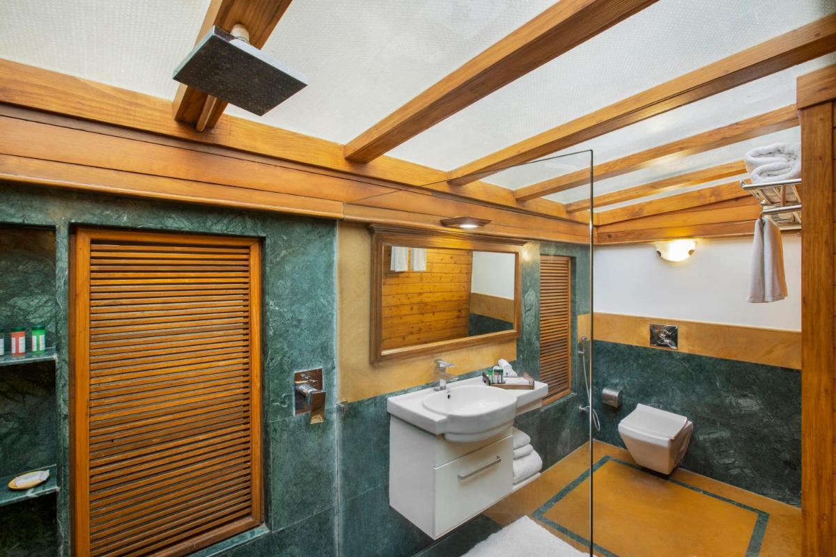 a bathroom with a sink and a toilet and a mirror at Raga on the Ganges, Rishikesh in Rishīkesh