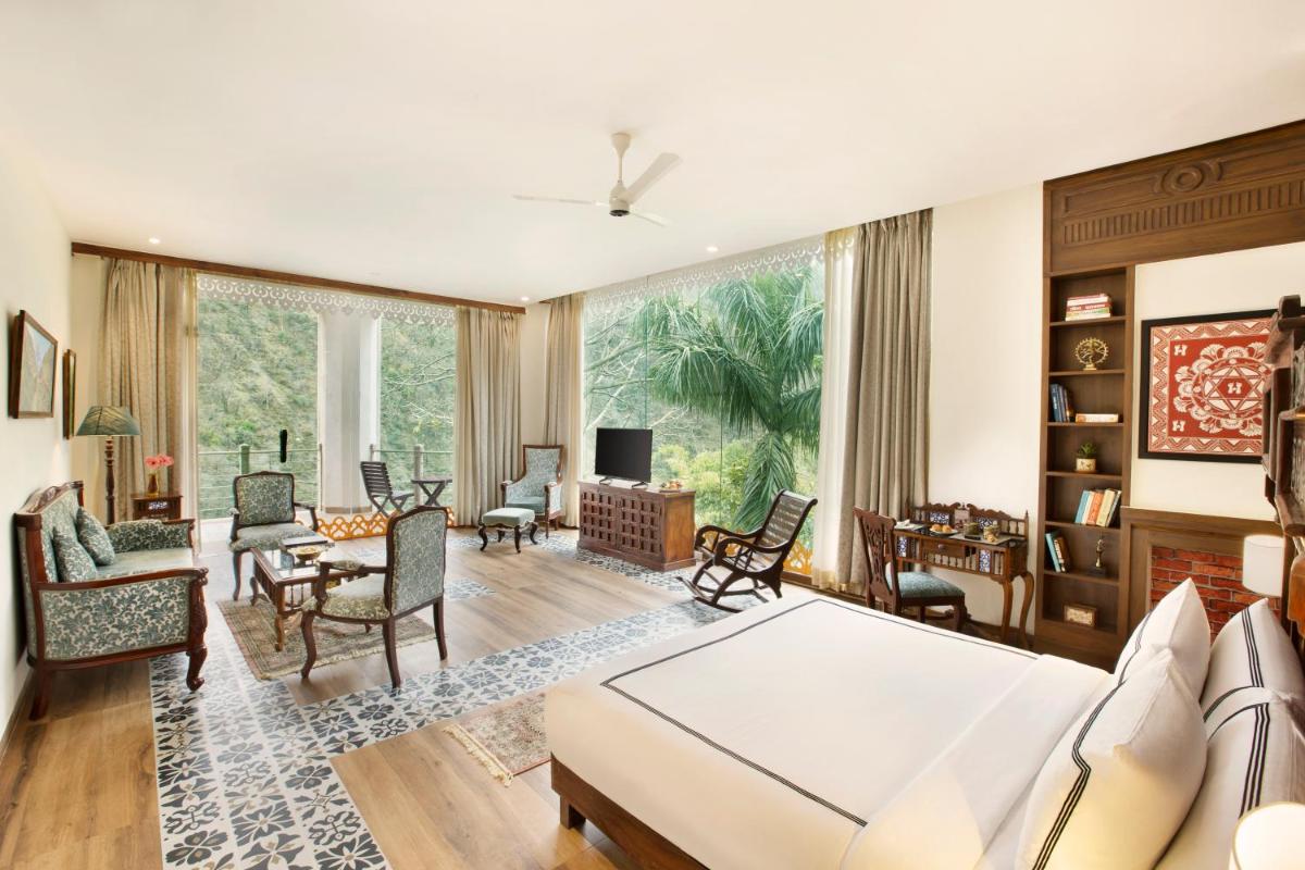 a living room filled with furniture and a large window at Raga on the Ganges, Rishikesh in Rishīkesh