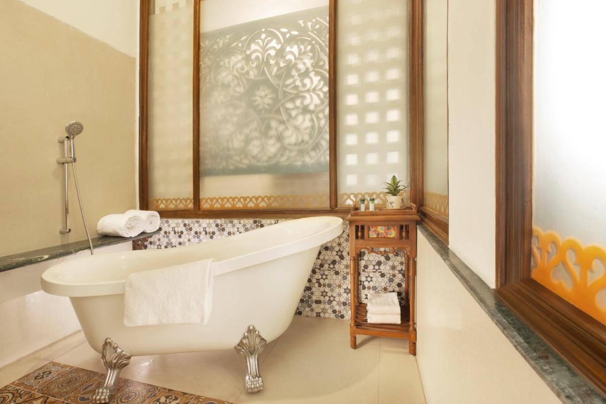 a bathroom with a tub and a sink at Raga on the Ganges, Rishikesh in Rishīkesh
