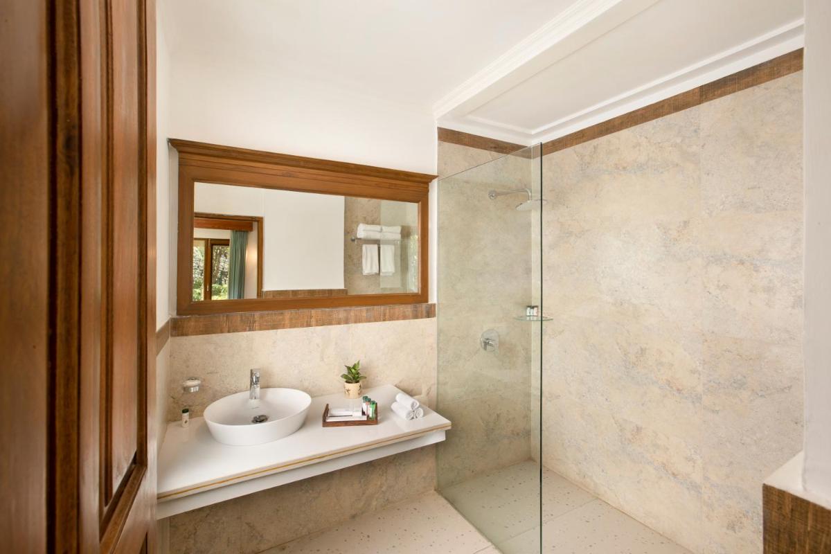 a bathroom with a sink and a glass shower at Raga on the Ganges, Rishikesh in Rishīkesh