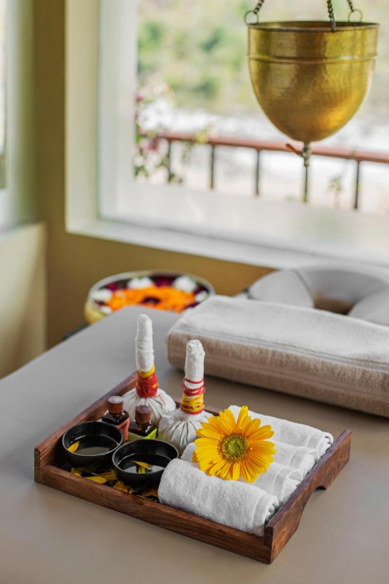 a tray with sauces and a flower on a table at Raga on the Ganges, Rishikesh in Rishīkesh