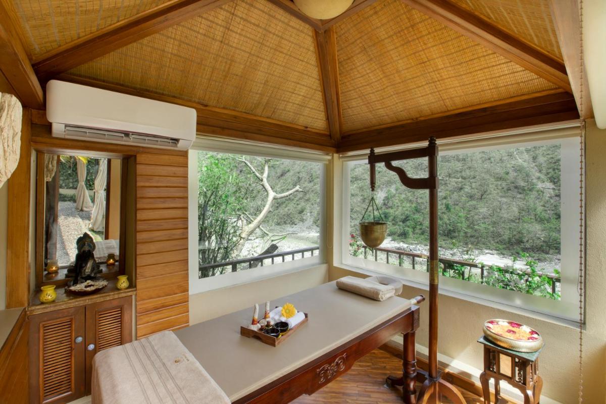 a room with a table and two windows at Raga on the Ganges, Rishikesh in Rishīkesh