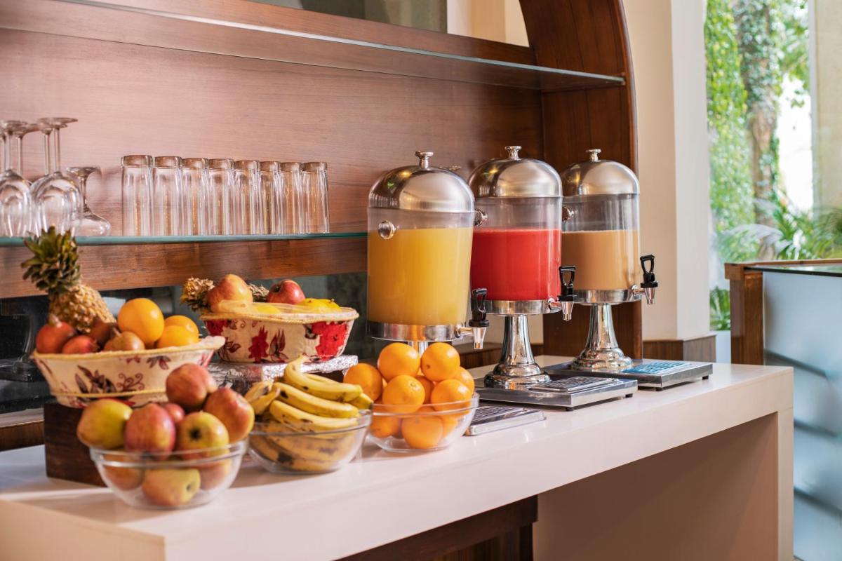 a buffet with fruit and juice on a counter at Raga on the Ganges, Rishikesh in Rishīkesh