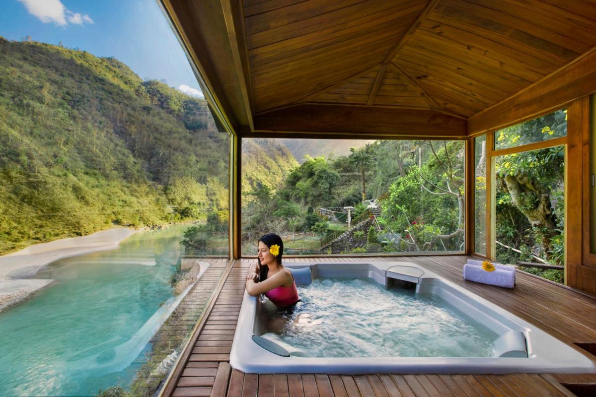 a woman sitting in a bath tub in the middle of a river at Raga on the Ganges, Rishikesh in Rishīkesh