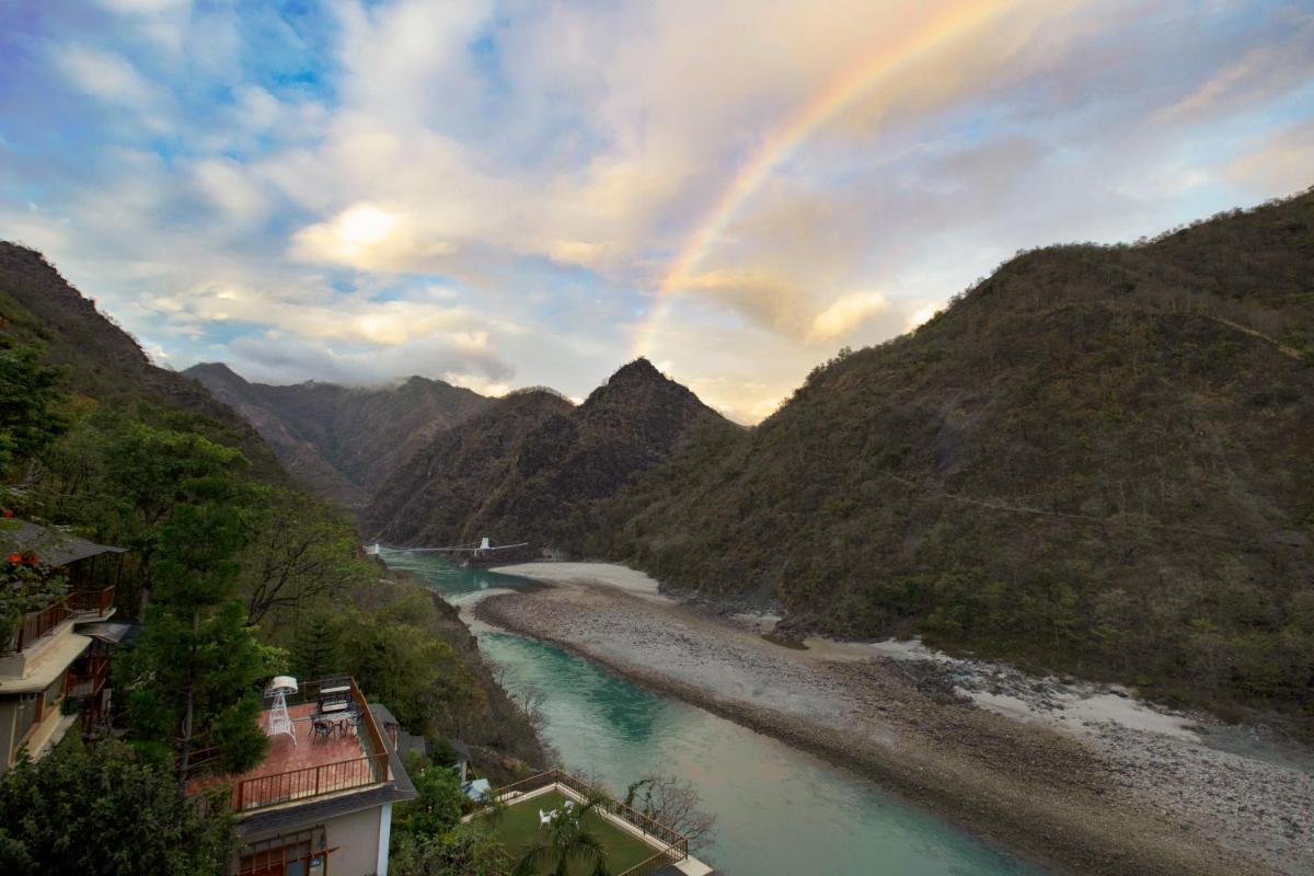 a rainbow over a river in a valley with mountains at Raga on the Ganges, Rishikesh in Rishīkesh