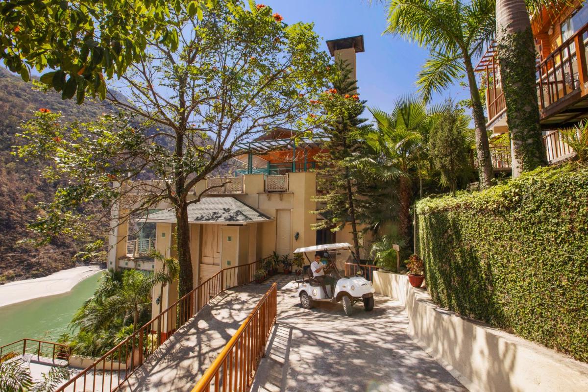 a walkway leading to a house with palm trees at Raga on the Ganges, Rishikesh in Rishīkesh