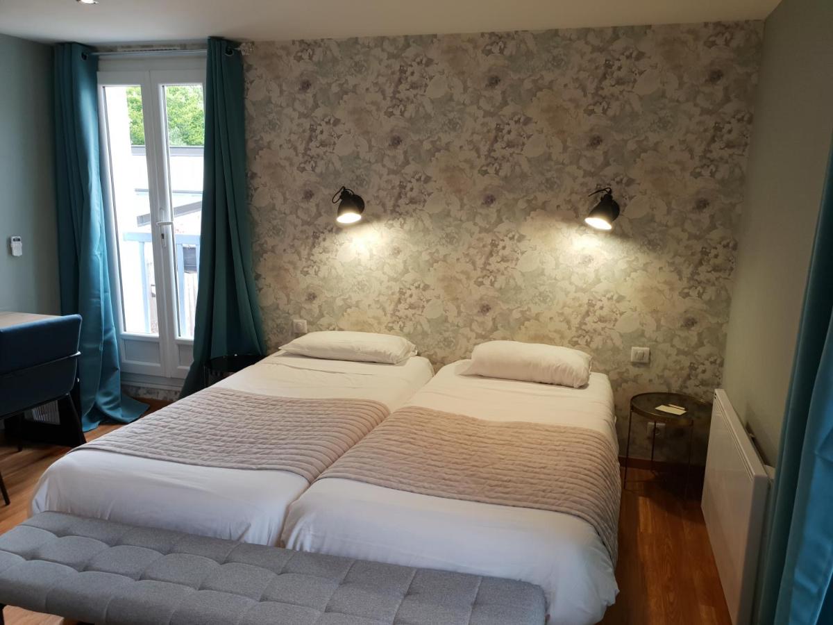 Un ou plusieurs lits dans un hébergement de l'établissement Logis Hôtel Restaurant Aux Maisons