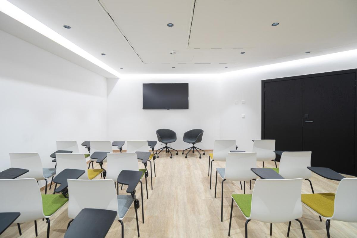 una sala de conferencias con sillas blancas y una pantalla en JS Palma Plaza, en Palma de Mallorca 72 fotos más