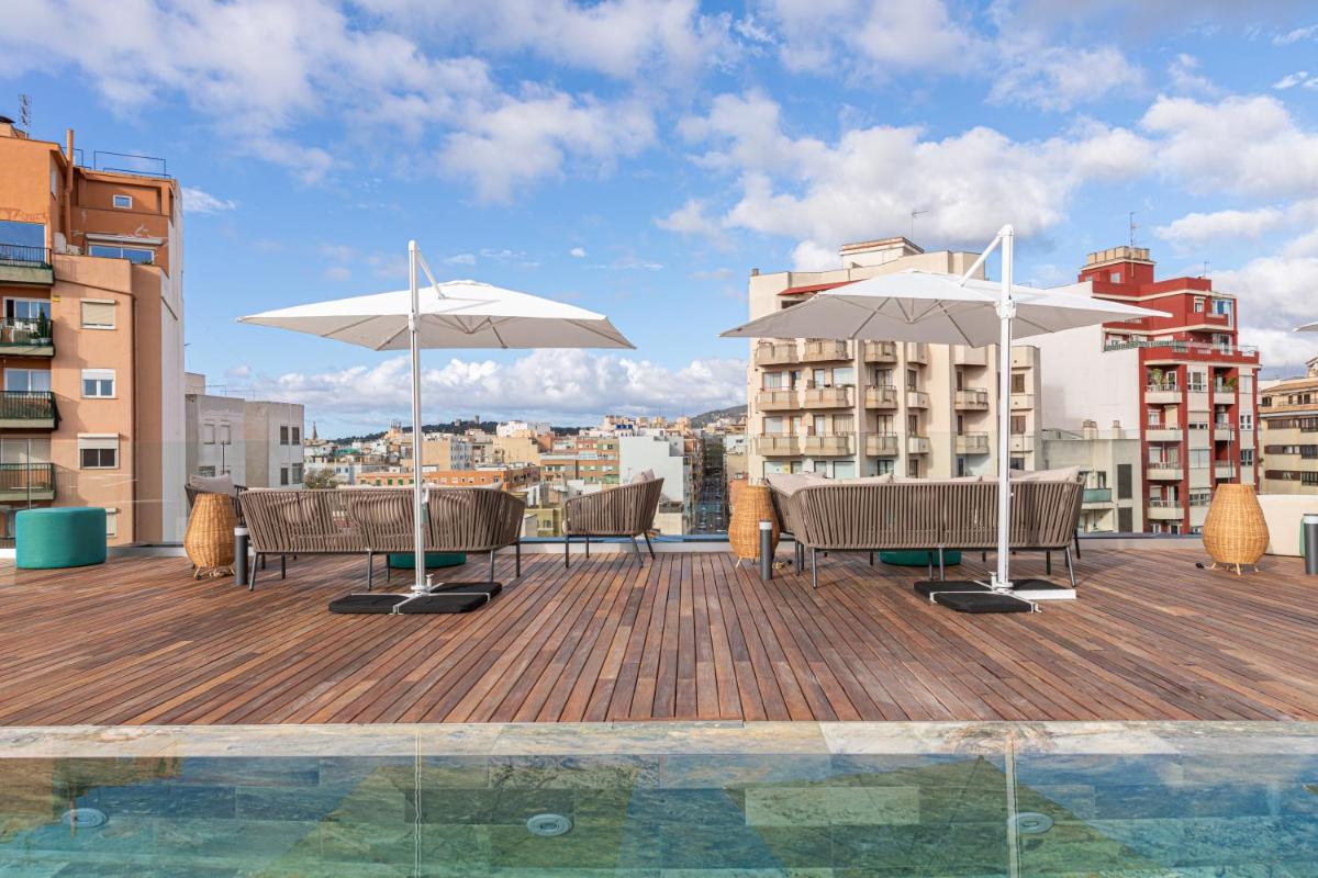 una terraza con sillas y sombrillas en un edificio en JS Palma Plaza, en Palma de Mallorca
