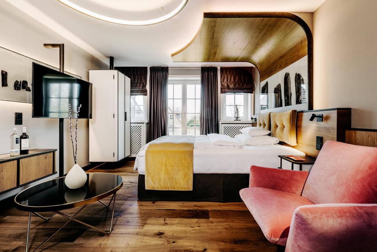 Ein Bett oder Betten in einem Zimmer der Unterkunft Relais & Châteaux Landhaus Stricker