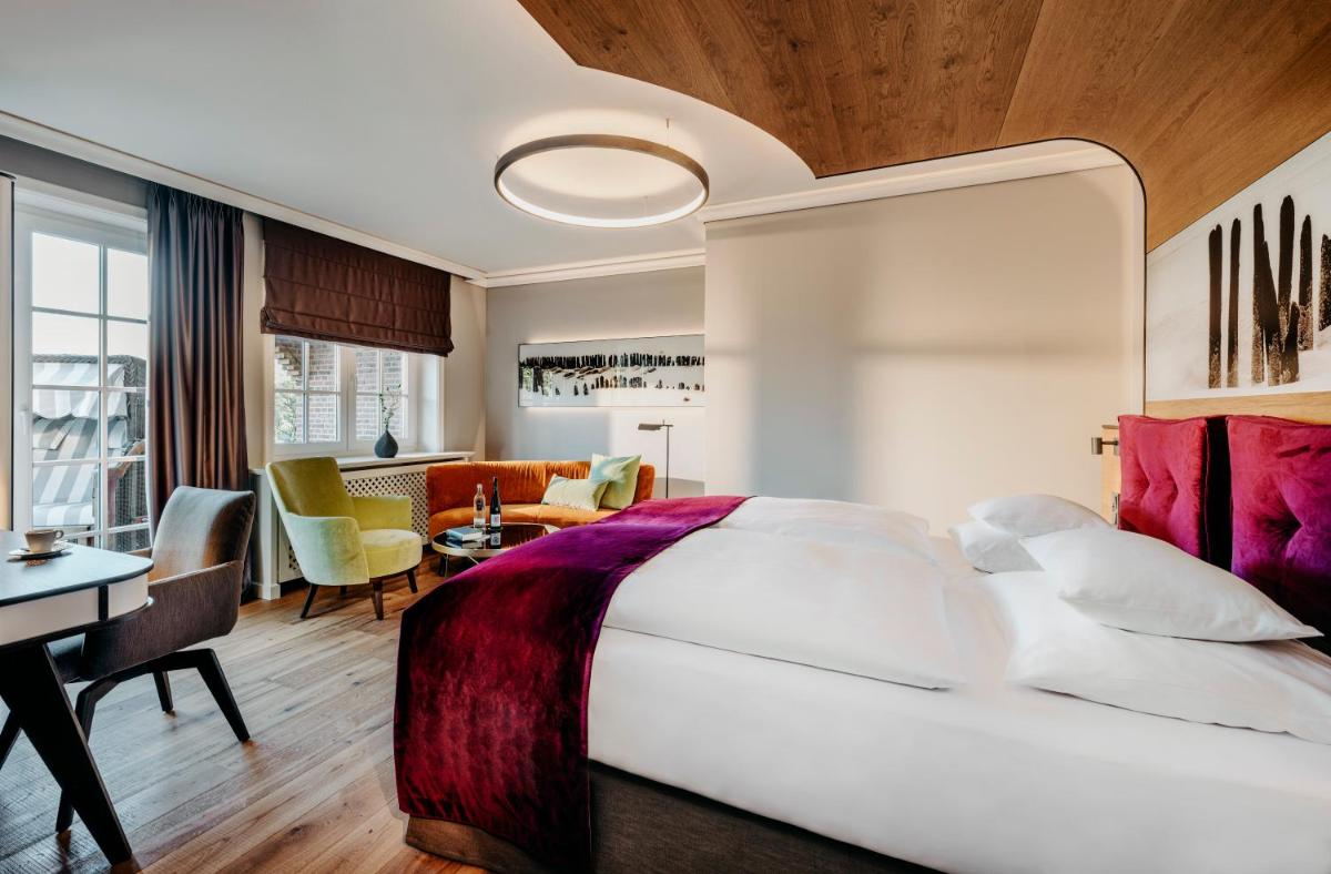 Ein Bett oder Betten in einem Zimmer der Unterkunft Relais & Châteaux Landhaus Stricker