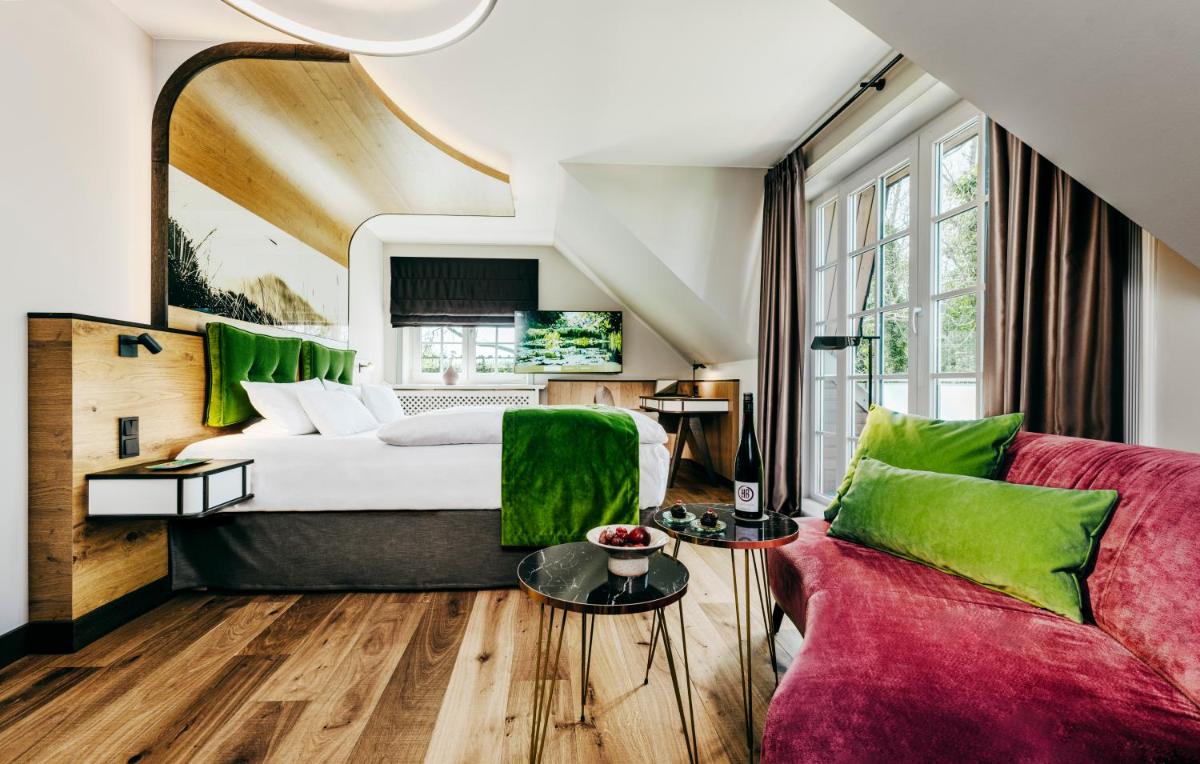 ein Hotelzimmer mit einem Bett und einer Couch in der Unterkunft Relais & Châteaux Landhaus Stricker in Tinnum ein Hotelzimmer mit einem Bett und einer Couch in der Unterkunft Relais & Châteaux Landhaus Stricker in Tinnum