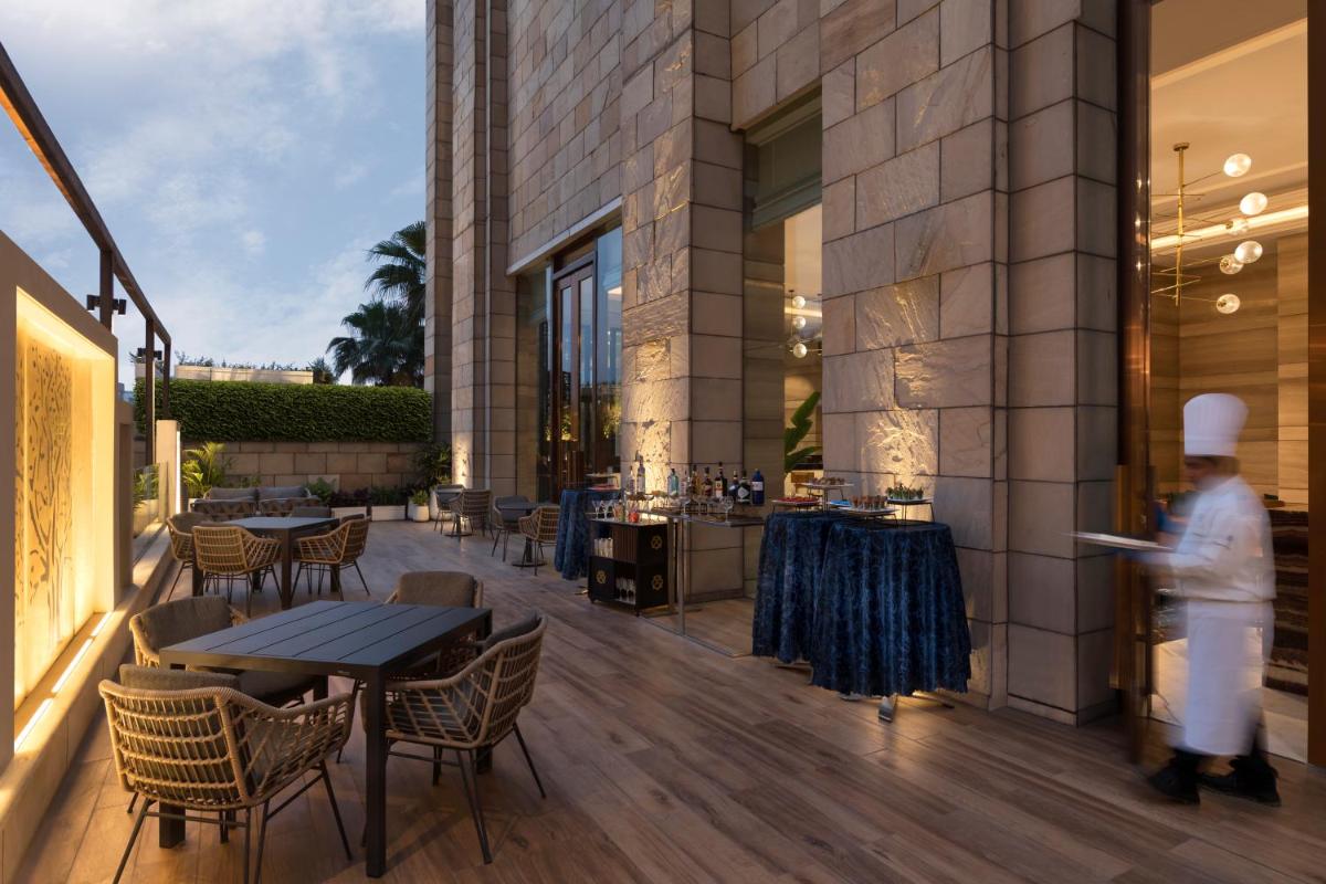 a person walking on a patio with tables and chairs at Crowne Plaza New Delhi Mayur Vihar Noida by IHG in New Delhi