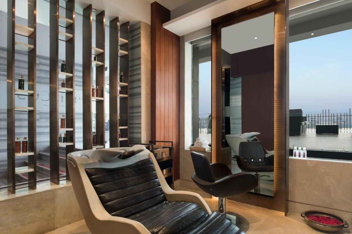a salon with a bench and chairs and a mirror at Crowne Plaza New Delhi Mayur Vihar Noida by IHG in New Delhi