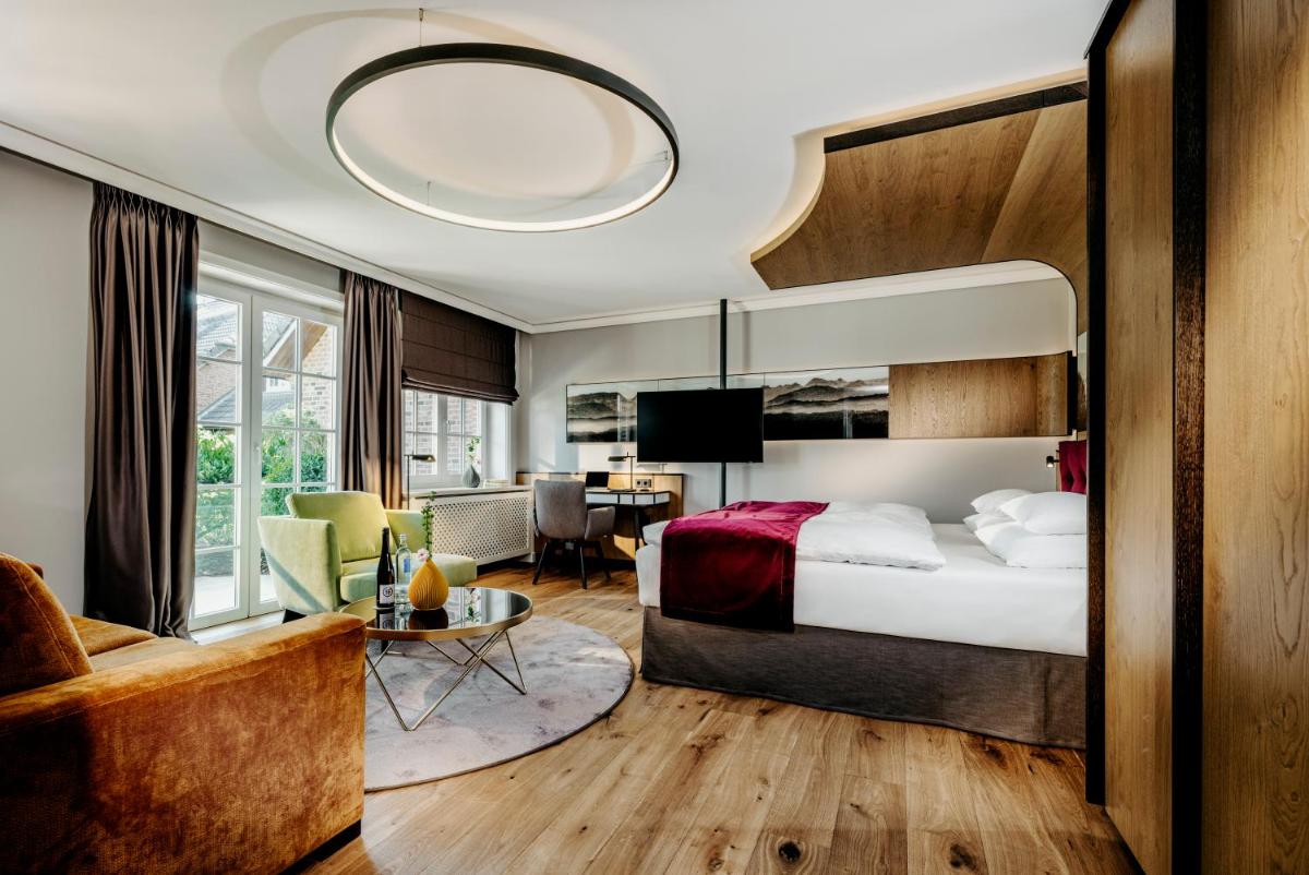 Ein Bett oder Betten in einem Zimmer der Unterkunft Relais & Châteaux Landhaus Stricker