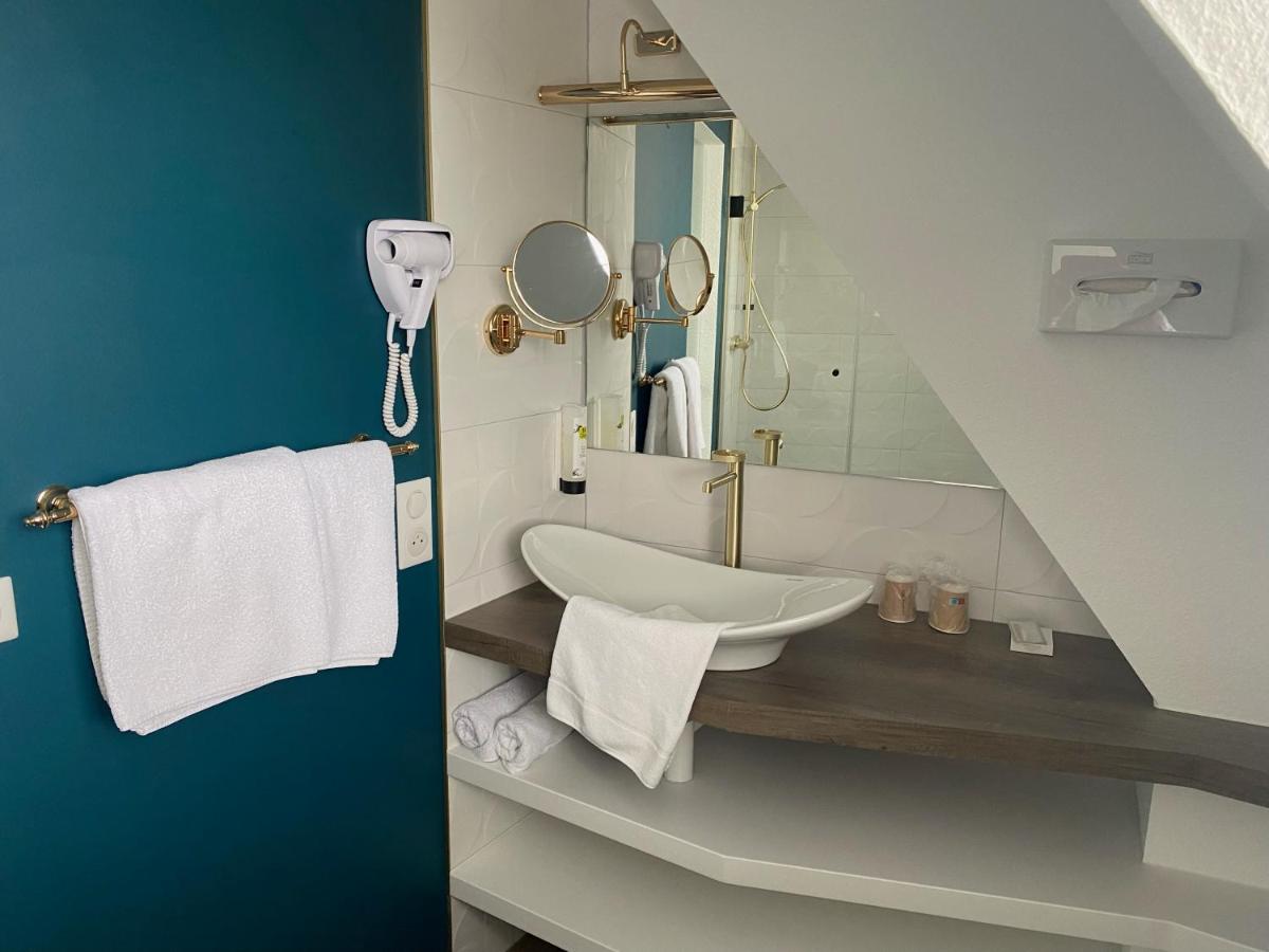 une salle de bain avec un lavabo et un miroir dans l'établissement Logis Hotel Restaurant A L'Etoile, à Mittelhausen