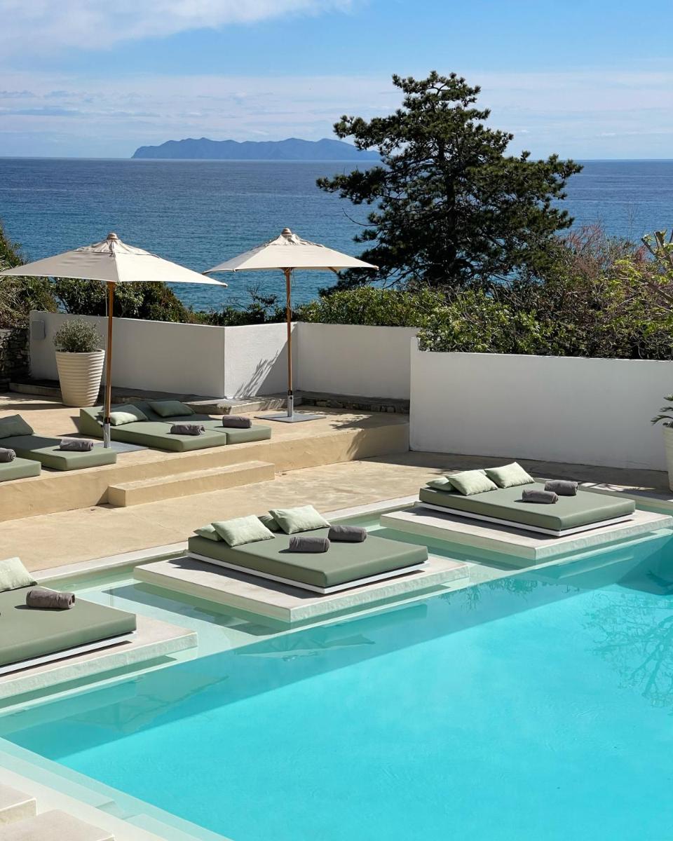 une piscine avec chaises longues et parasols dans l'établissement Misincu, à Cagnano