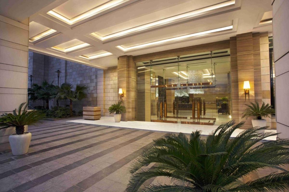 a lobby with potted plants in a building at Crowne Plaza New Delhi Mayur Vihar Noida by IHG in New Delhi