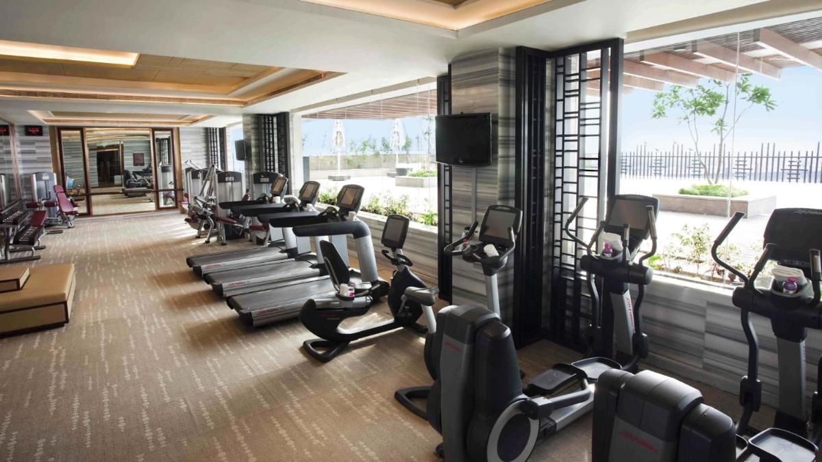 a gym with a bunch of treadmills and ellipticals at Crowne Plaza New Delhi Mayur Vihar Noida by IHG in New Delhi
