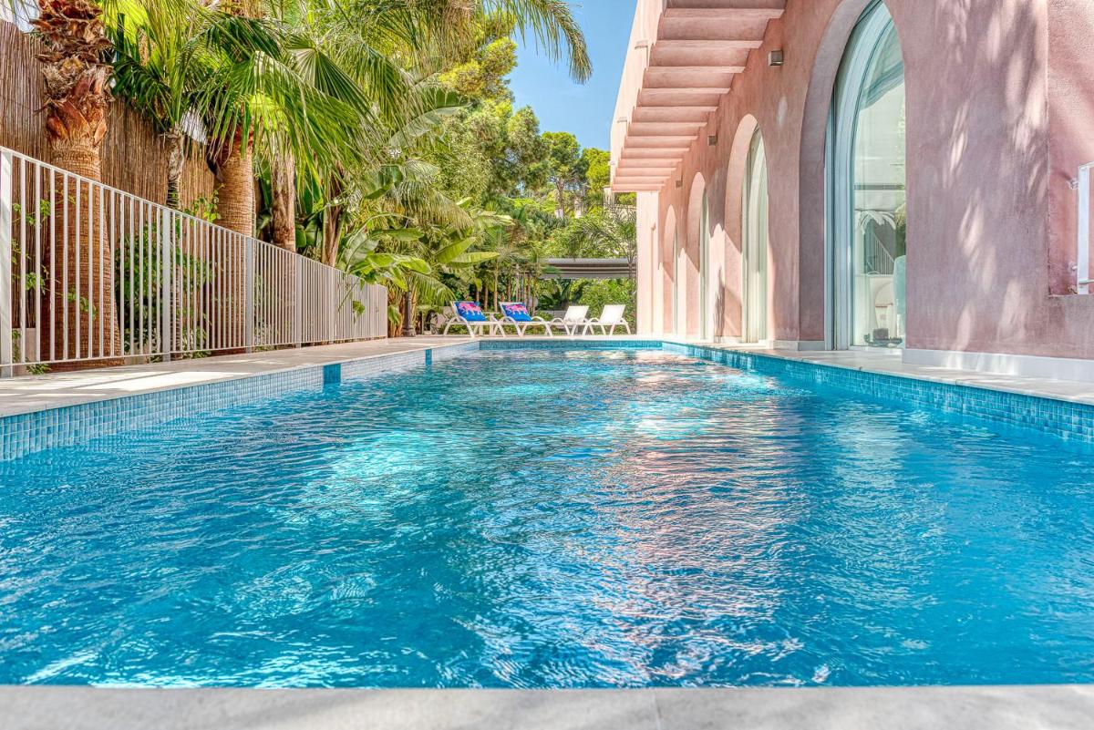 una piscina con agua azul en una casa en The Pink Elephant Hotel, en S'Agaró