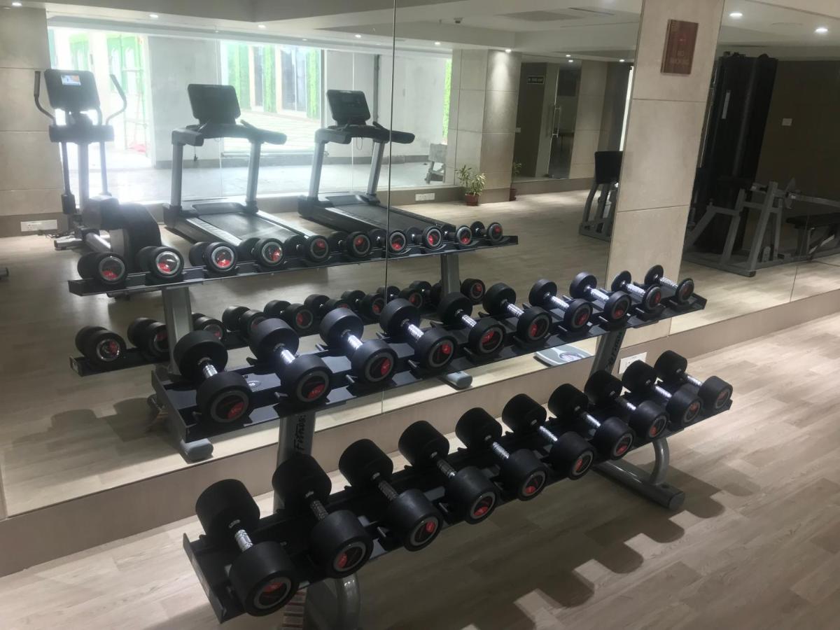 a gym with rows of dumbbells on display at Ramada Plaza by Wyndham Lucknow in Lucknow