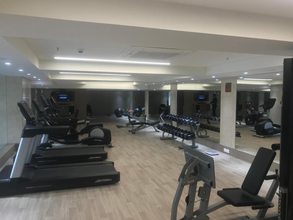 a gym with treadmills and exercise bikes in it at Ramada Plaza by Wyndham Lucknow in Lucknow