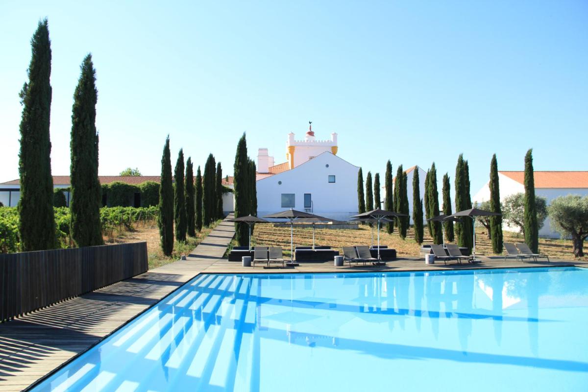 uma piscina em frente a uma villa com árvores em Torre de Palma Wine Hotel, Monforte, a Member of Design Hotels em Monforte