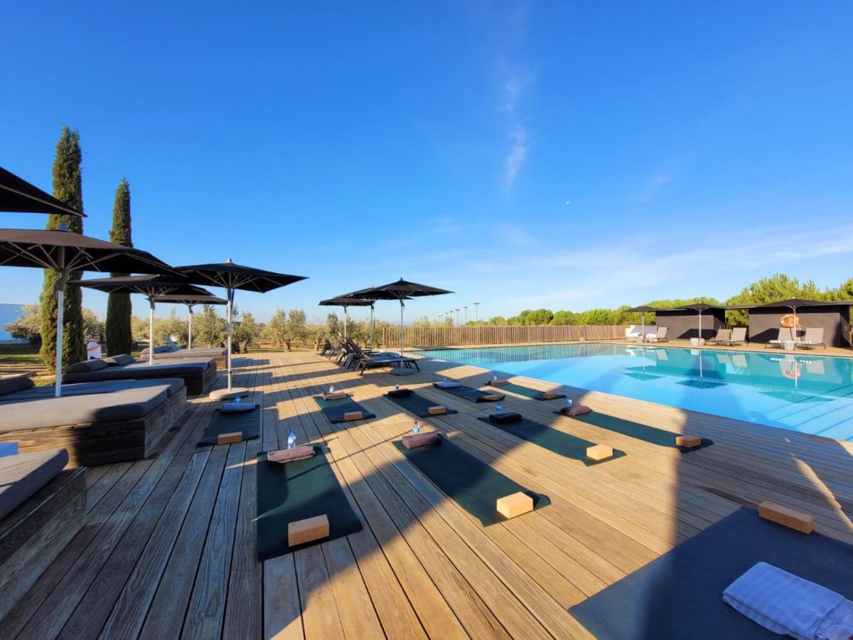 uma piscina com espreguiçadeiras e guarda-sóis em Torre de Palma Wine Hotel, Monforte, a Member of Design Hotels em Monforte