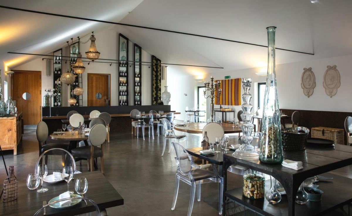 um restaurante com mesas e cadeiras em uma sala em Torre de Palma Wine Hotel, Monforte, a Member of Design Hotels em Monforte