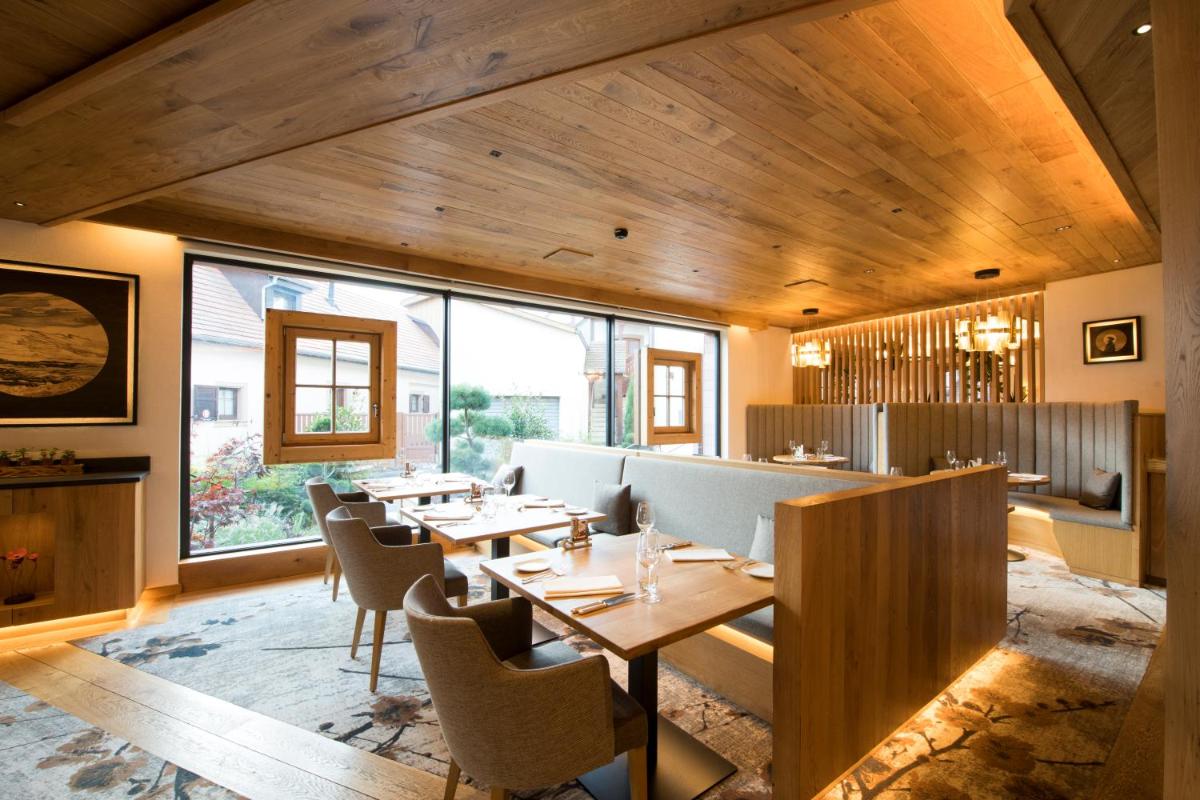 un restaurant avec des plafonds en bois, des tables et des chaises dans l'établissement Hostellerie Des Châteaux & Spa, à Ottrott
