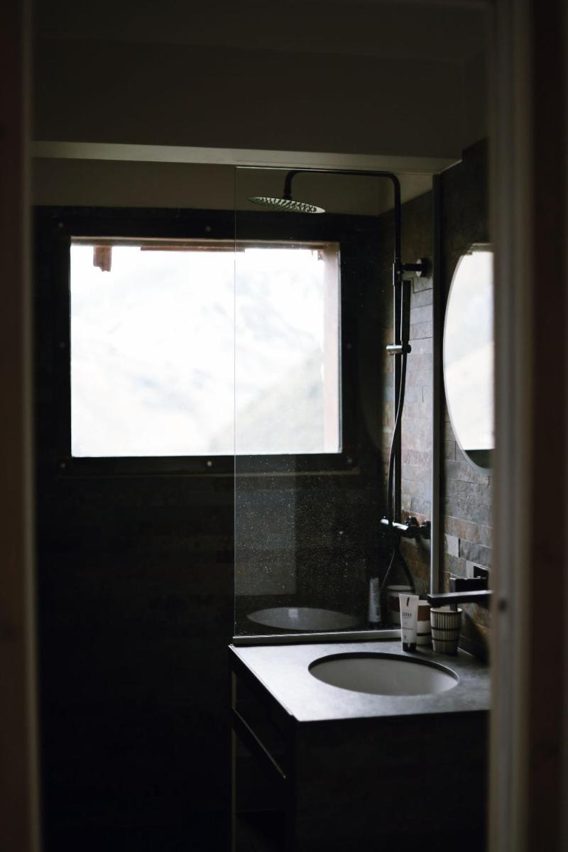 une salle de bains avec lavabo et une grande fenêtre dans l'établissement Les Cèdres - Hôtel - Restaurants - Spa, à Saint-Sorlin-dʼArves