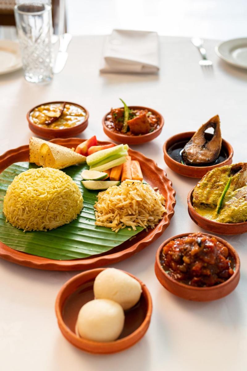 a table with plates of different types of food at Raajkutir - IHCL SeleQtions in Kolkata
