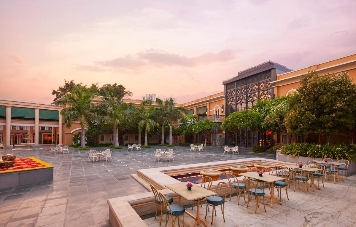a courtyard with tables and chairs in front of a building at Raajkutir - IHCL SeleQtions in Kolkata