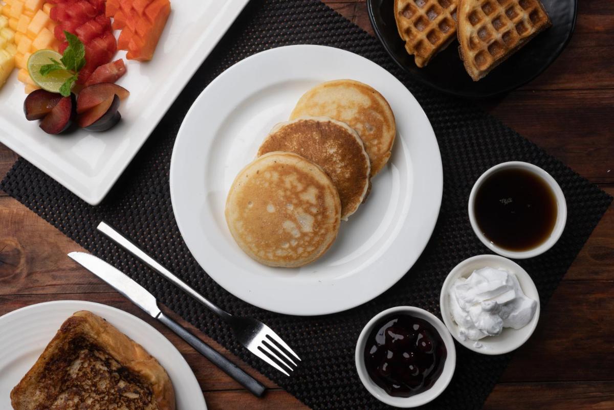 a table with a plate of food with bread and waffles at Bengaluru Marriott Hotel Whitefield in Bengaluru