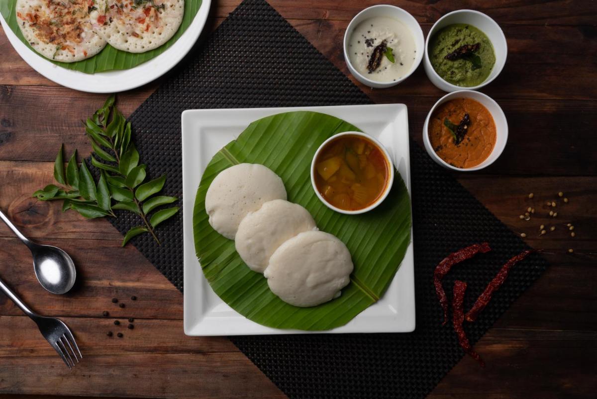 a plate of food with two rolls on a banana leaf at Bengaluru Marriott Hotel Whitefield in Bengaluru