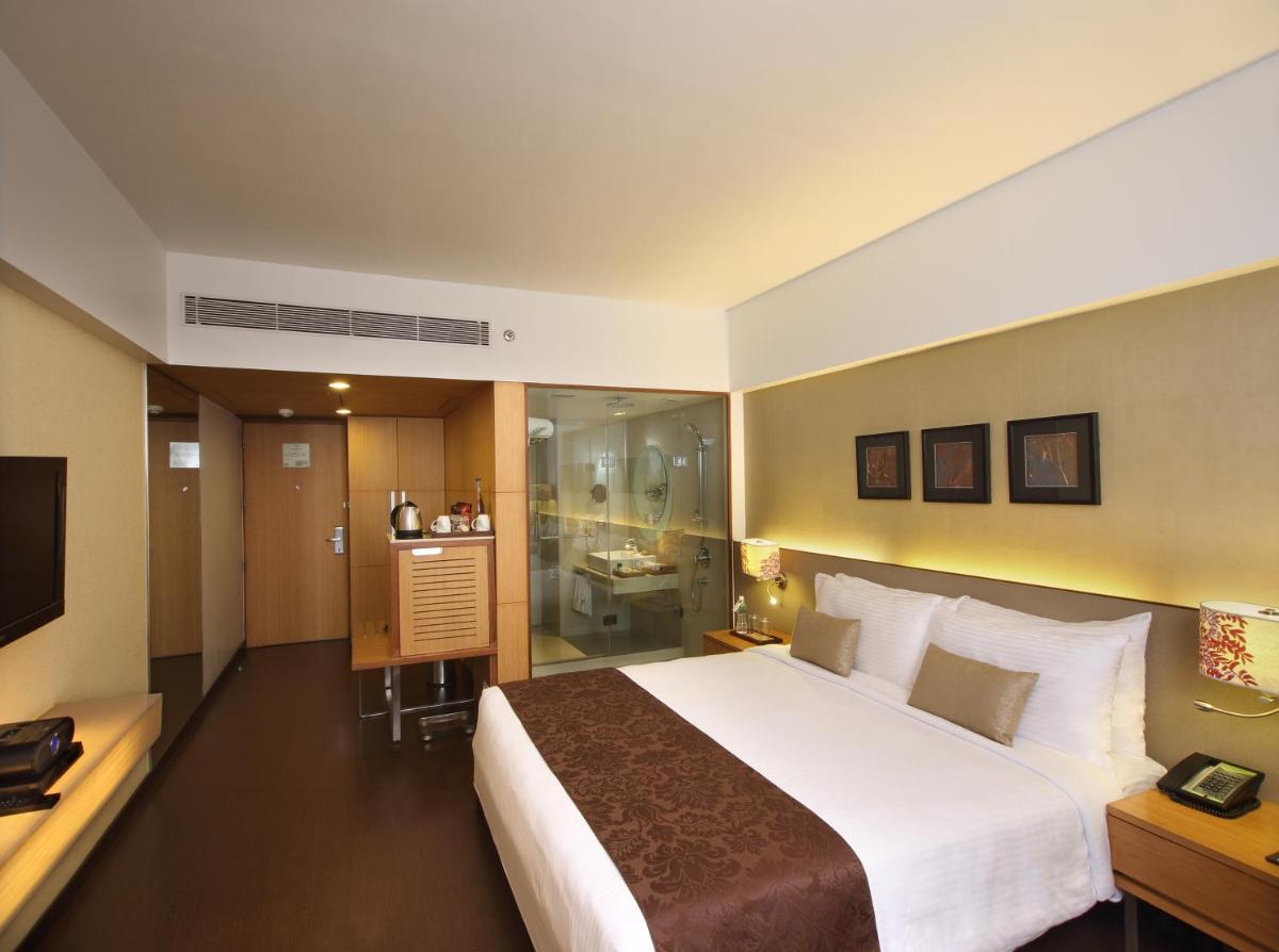 a hotel room with a large bed and a bathroom at Fortune Select SG Highway, Ahmedabad - Member ITC Hotels' Group in Ahmedabad