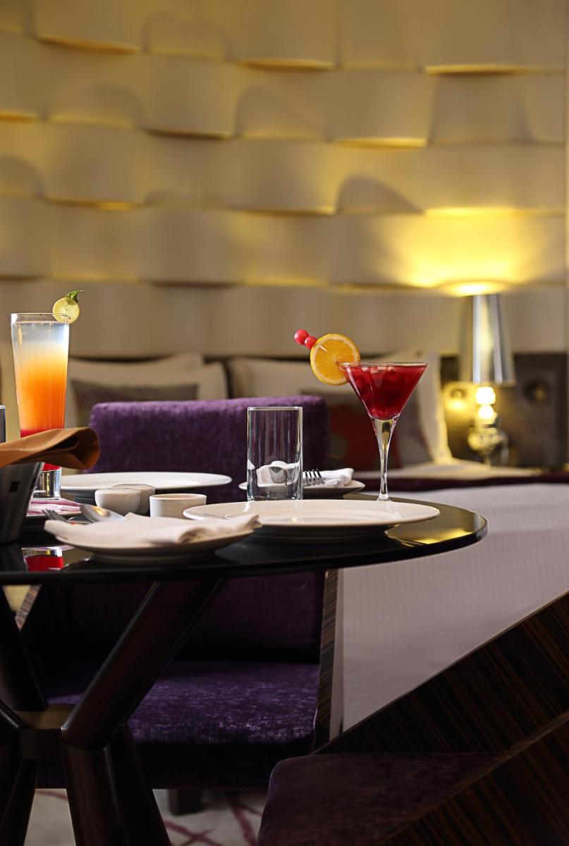 a table with a drink and two glasses on it at Fortune Select SG Highway, Ahmedabad - Member ITC Hotels' Group in Ahmedabad