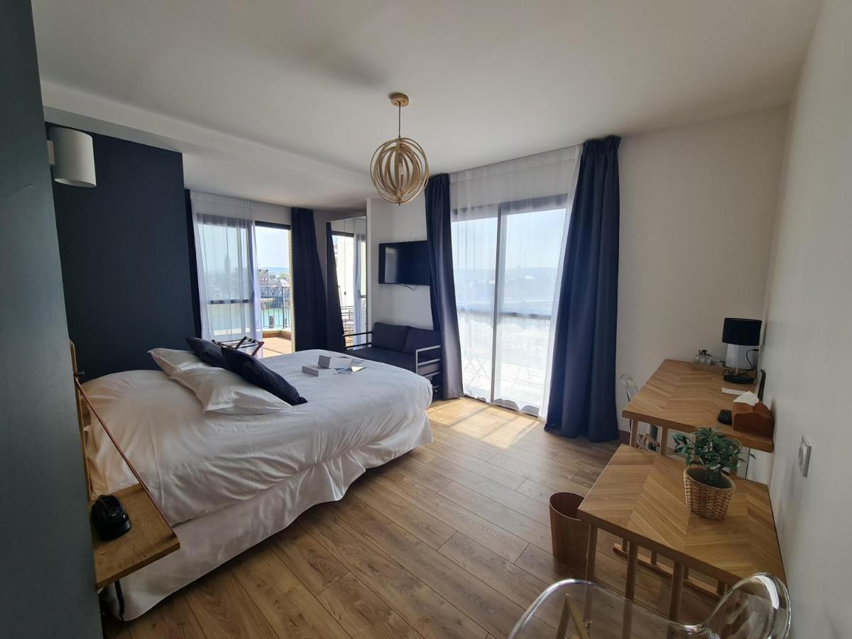 - une chambre avec un lit aux murs bleus et une table dans l'établissement LA TOUR AUX CRABES près de la plage, à Dieppe