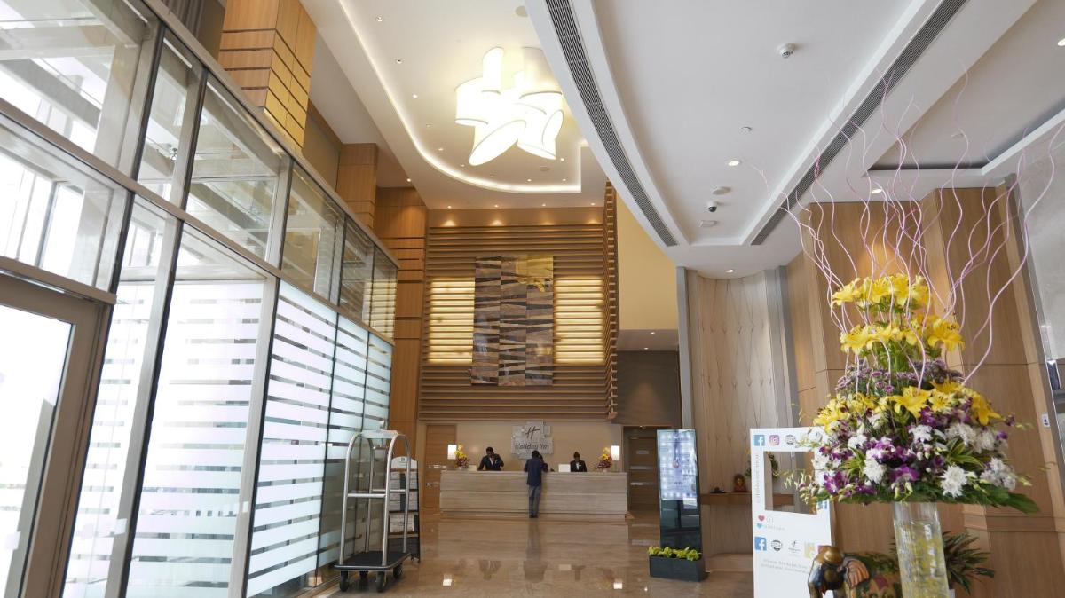 a lobby of a building with flowers on display at Holiday Inn Chennai OMR IT Expressway by IHG in Chennai