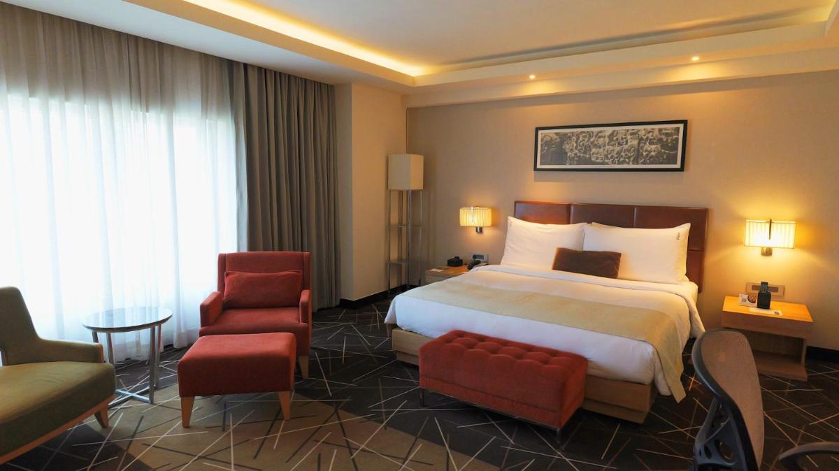 a hotel room with a bed and a chair at Holiday Inn Chennai OMR IT Expressway by IHG in Chennai
