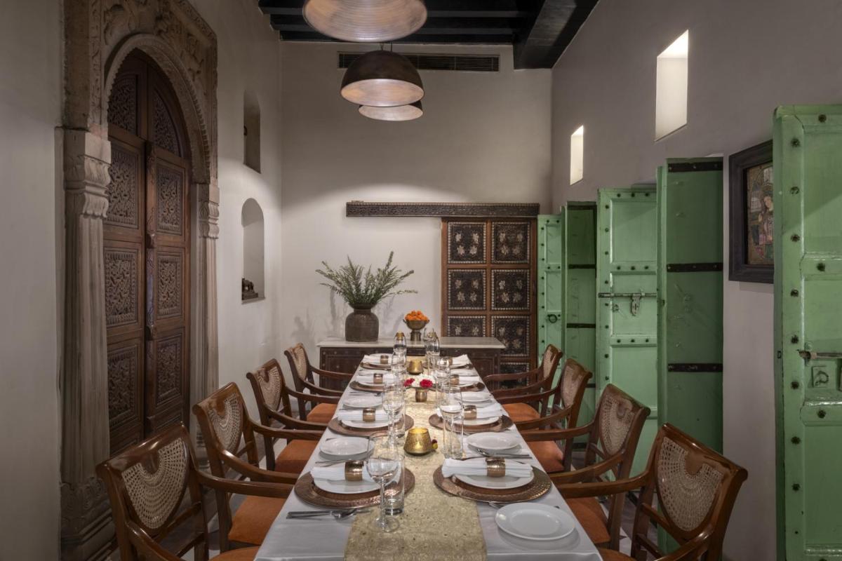 a long dining room with a long table and chairs at Haveli Dharampura & Golden Haveli- UNESCO awarded Boutique Heritage Hotel in New Delhi a long dining room with a long table and chairs at Haveli Dharampura & Golden Haveli- UNESCO awarded Boutique Heritage Hotel in New Delhi