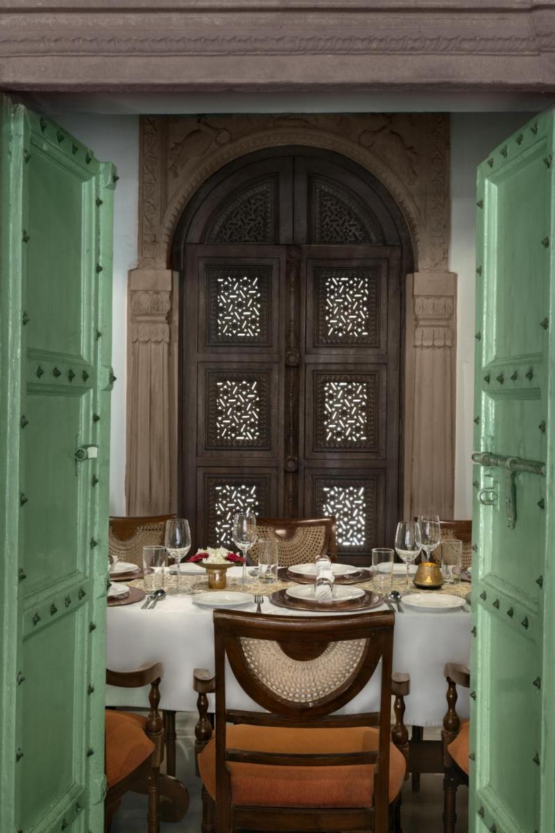 a dining room with a table with wine glasses at Haveli Dharampura & Golden Haveli- UNESCO awarded Boutique Heritage Hotel in New Delhi a dining room with a table with wine glasses at Haveli Dharampura & Golden Haveli- UNESCO awarded Boutique Heritage Hotel in New Delhi