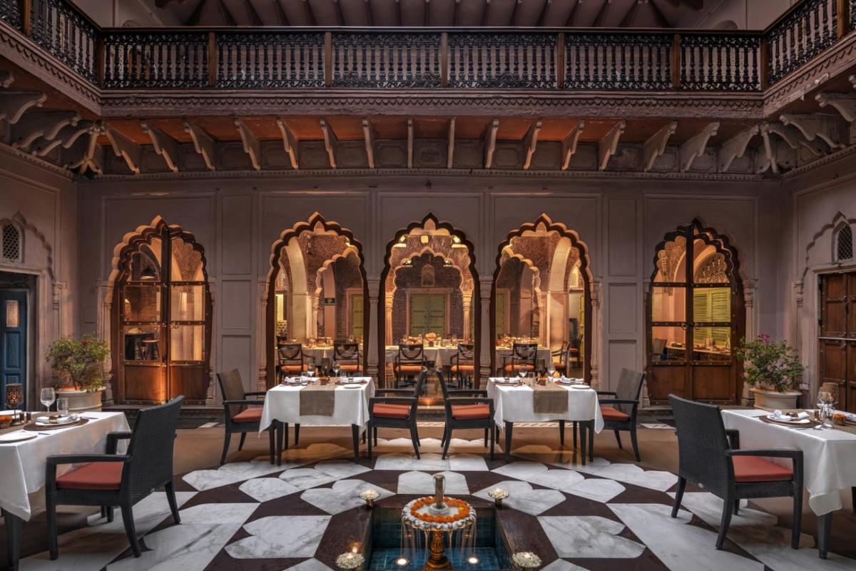 a dining room with tables and chairs and a ceiling at Haveli Dharampura & Golden Haveli- UNESCO awarded Boutique Heritage Hotel in New Delhi a dining room with tables and chairs and a ceiling at Haveli Dharampura & Golden Haveli- UNESCO awarded Boutique Heritage Hotel in New Delhi