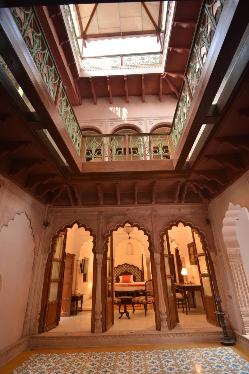 an ornate room with a glass ceiling and a table at Haveli Dharampura & Golden Haveli- UNESCO awarded Boutique Heritage Hotel in New Delhi an ornate room with a glass ceiling and a table at Haveli Dharampura & Golden Haveli- UNESCO awarded Boutique Heritage Hotel in New Delhi