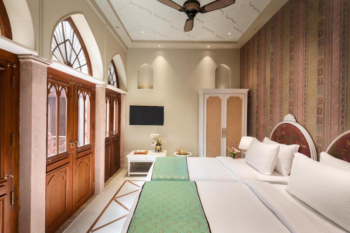 a hotel room with a bed and a television at Haveli Dharampura & Golden Haveli- UNESCO awarded Boutique Heritage Hotel in New Delhi a hotel room with a bed and a television at Haveli Dharampura & Golden Haveli- UNESCO awarded Boutique Heritage Hotel in New Delhi
